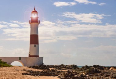 Salvador, Bahia - Brazil. Lighthouse on Itapu beach, beach, sea; rocks and blue sky. Sea turtle spawning area.