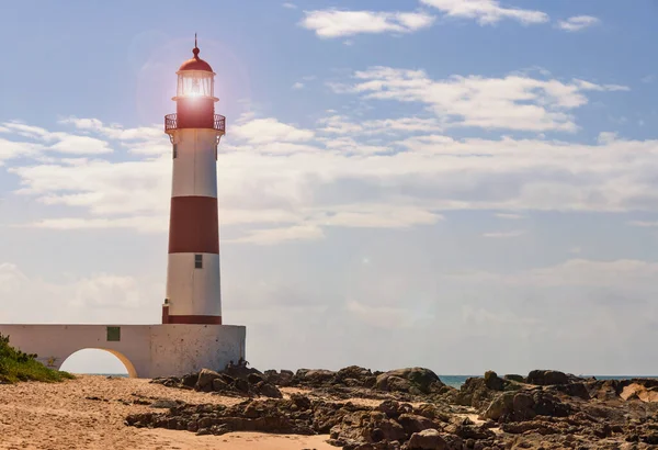Salvador, Bahia - Brazil. Lighthouse on Itapu beach, beach, sea; rocks and blue sky. Sea turtle spawning area.