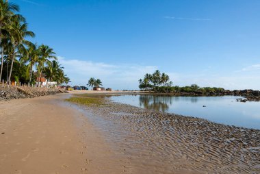 Morro de Sao Paulo, Bahia, Brazil. Early in the morning on the second beach in the village. Low tide, blue sky with white clouds and reflection in the water mirror.