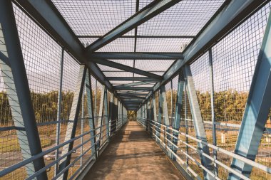 Pedestrian bridge in metallic structure with railings over the highway. D. Pedro I highway, Atibaia, Brazil.