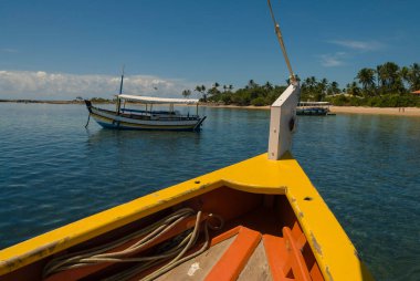 Bow of a yellow wooden boat near the beach in the village of Morro de Sao Paulo, Bahia, Brazil on a sunny day