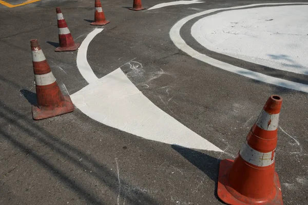 Traffic signage. Asphalt painting. Direction arrow at intersection roundabout.