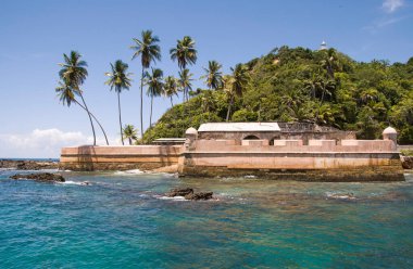 Tapirandu Kalesi, Morro de Sao Paulo, Brezilya. Taşlar ve balina yağından yapılmış 17. yüzyıl. Mavi gökyüzü, palmiye ağaçları ve turkuaz deniz..