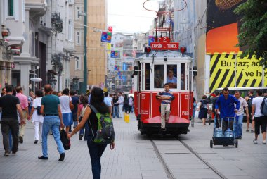 İstiklal, İstanbul, Türkiye - 11 Eylül 2009: Çocuk Taksim 'deki geleneksel kırmızı tramvayın önünde otostop çekiyor. Hem turistler hem de İstanbul 'un yerli halkı için popüler bir yer.