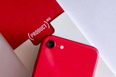 Akıllı telefonmuş. Kutunun üzerinde Apple iPhone SE Second Edition Product Red 'in kısmi arka görüntüsü ve 