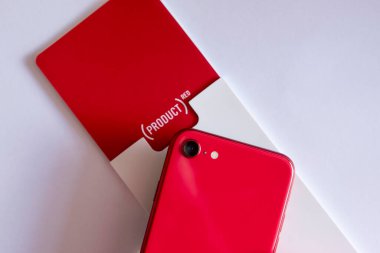 Akıllı telefonmuş. Kutunun üzerinde Apple iPhone SE Second Edition Product Red 'in kısmi arka görüntüsü ve 