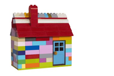 Plastik bloklardan yapılmış renkli bir ev. Baca, çatı ve kapı. Metin için boşluk olan beyaz arkaplan. EPS illüstrasyonu. 