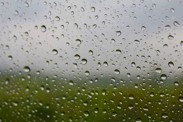 Rain drops on window glasses surface. Rain drops isolated on cloudy background