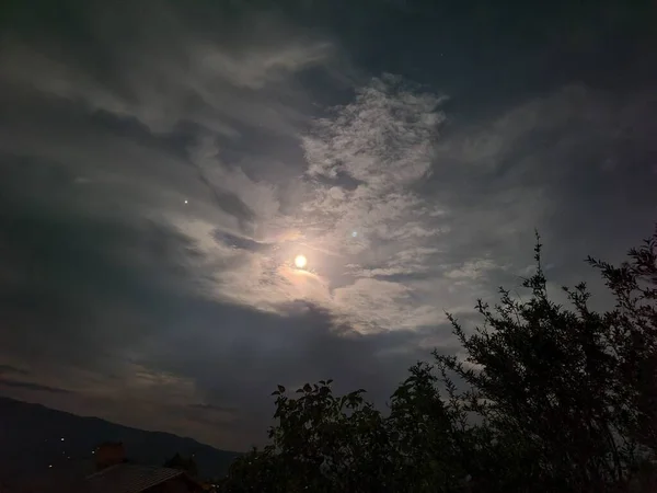 full moon with clouds in the mountains at night