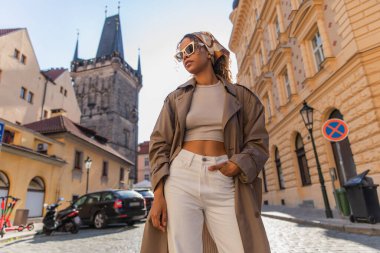 low angle view of stylish african american woman posing near old town hall tower in prague