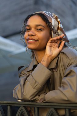 tattooed african american woman with tattoo on hand smiling outside