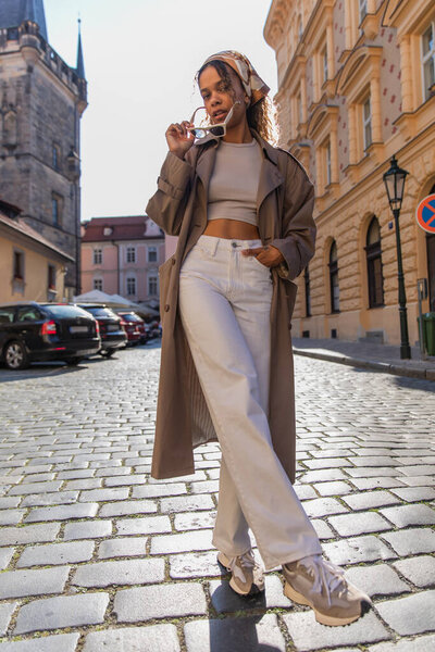 стильная африканская американка позирует в солнцезащитных очках возле старой ратуши в Праге