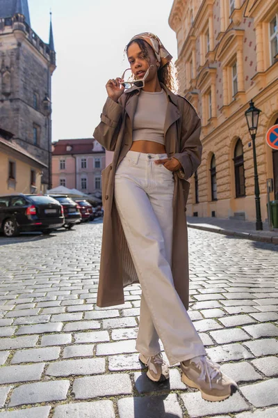 Stylish african american woman posing with sunglasses near old town hall tower in prague — Stock Photo