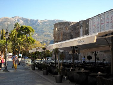 A cafe in Kotor in the shadow of city walls prepares for the busy day