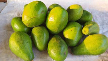 pile of buttered avocados on a white background