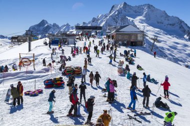Kafkasya Dağları, Belalakaya, Sofrudzhu ve Sulakhat dağları ile kayak yamacının panoramik manzarası kış günü ufukta. Dombai kayak merkezi, Batı Kafkasya, Karachai-Cthe, Rusya-5 Mart 2021.