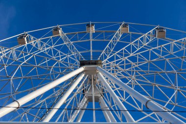 Mavi gökyüzünün arka planında dönme dolap, lunapark, çocuklarla tatil