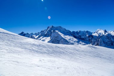 Kafkasya Dağları, Belalakaya, Sofrudzhu ve Sulakhat dağları ile kayak yamacının panoramik manzarası kış günü ufukta. Dombai kayak merkezi, Batı Kafkasya, Karachai-Cthe, Rusya.