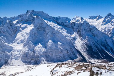 Kafkasya Dağları, Belalakaya, Sofrudzhu ve Sulakhat dağları ile kayak yamacının panoramik manzarası kış günü ufukta. Dombai kayak merkezi, Batı Kafkasya, Karachai-Cthe, Rusya.