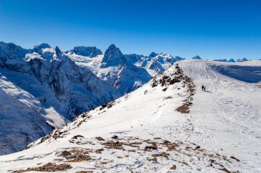 Kafkasya Dağları, Belalakaya, Sofrudzhu ve Sulakhat dağları ile kayak yamacının panoramik manzarası kış günü ufukta. Dombai kayak merkezi, Batı Kafkasya, Karachai-Cthe, Rusya.