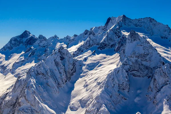 Kafkasya Dağları, Belalakaya, Sofrudzhu ve Sulakhat dağları ile kayak yamacının panoramik manzarası kış günü ufukta. Dombai kayak merkezi, Batı Kafkasya, Karachai-Cthe, Rusya.