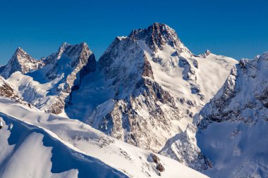 Kafkasya Dağları, Belalakaya, Sofrudzhu ve Sulakhat dağları ile kayak yamacının panoramik manzarası kış günü ufukta. Dombai kayak merkezi, Batı Kafkasya, Karachai-Cthe, Rusya.
