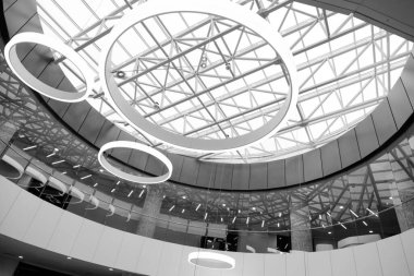 Binaların modern mimarisi, metal yapıların detaylarındaki soyutlama, cam ve beton. Çağdaş çehrenin eğri köşegen çizgileri üzerinde soyut gölgeler ve ışık deseni. Cam bina cephesinin bir parçası, B & W