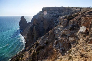 Kırım 'daki Karadeniz kıyısı, Sivastopol' daki Cape Fiolent manzarası. Panoramik deniz manzarası, sakin gök mavisi deniz, bulutlar ve parlak gökyüzü..