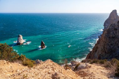 Kırım 'daki Karadeniz kıyısı, Sivastopol' daki Cape Fiolent manzarası. Panoramik deniz manzarası, sakin gök mavisi deniz, bulutlar ve parlak gökyüzü..