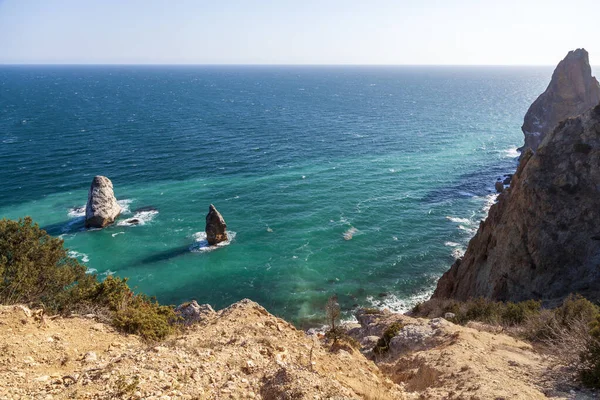 Kırım 'daki Karadeniz kıyısı, Sivastopol' daki Cape Fiolent manzarası. Panoramik deniz manzarası, sakin gök mavisi deniz, bulutlar ve parlak gökyüzü..