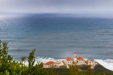 Figueira da Foz, Coimbra, Portekiz - 25 Ekim 2020: Kötü bir sonbahar gününde okyanusa bakan Cabo Mondego deniz fenerinin mimarisi ve çevresi