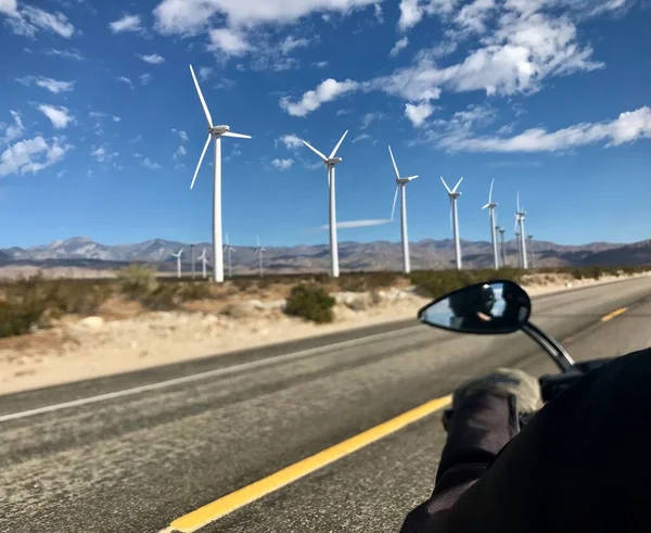 Passenger taken a photo of active windmills from the back of a 2022 Harley Davidson Street glide special in the desert outside of Bishop California.