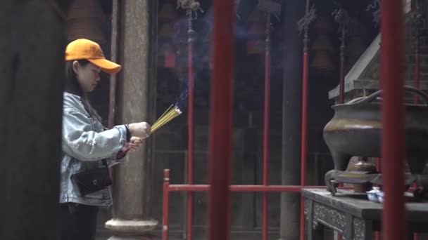 Asiatisk kvinna gör offer för brinnande rökelser tempel — Stockvideo