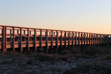 Sunset over the walkway of the dunes of the salt flats of San Pedro del Pinatar