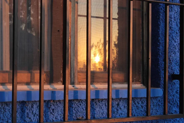 Reflections of the sunset in the window of a traditional house in the Murcian orchard