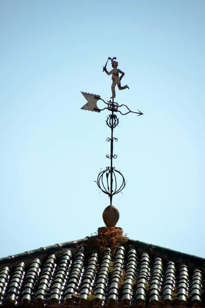 Traditional wrought iron weathervane on the roof of a village house.