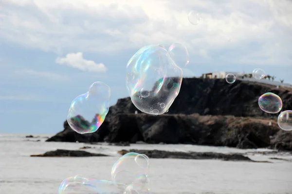 Large soap bubbles flying over the sea at Cabo de Palos. Cartagena. Murcia. Spain.