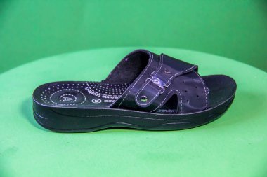 Illustrative Editorial branded photography, Slipper shouted on green Background, shot is selective focus with shallow depth of field. Photos taken at Cairo Egypt on 28 March 2019