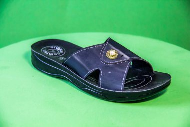 Illustrative Editorial branded photography, Slipper shouted on green Background, shot is selective focus with shallow depth of field. Photos taken at Cairo Egypt on 28 March 2019