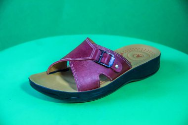 Illustrative Editorial branded photography, Slipper shouted on green Background, shot is selective focus with shallow depth of field. Photos taken at Cairo Egypt on 28 March 2019