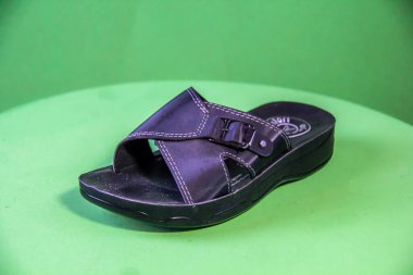 Illustrative Editorial branded photography, Slipper shouted on green Background, shot is selective focus with shallow depth of field. Photos taken at Cairo Egypt on 28 March 2019
