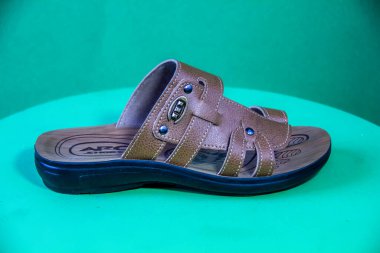Illustrative Editorial branded photography, Slipper shouted on green Background, shot is selective focus with shallow depth of field. Photos taken at Cairo Egypt on 28 March 2019