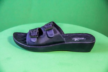 Illustrative Editorial branded photography, Slipper shouted on green Background, shot is selective focus with shallow depth of field. Photos taken at Cairo Egypt on 28 March 2019