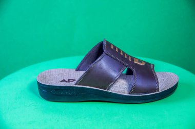 Illustrative Editorial branded photography, Slipper shouted on green Background, shot is selective focus with shallow depth of field. Photos taken at Cairo Egypt on 28 March 2019