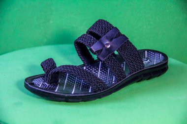 Illustrative Editorial branded photography, Slipper shouted on green Background, shot is selective focus with shallow depth of field. Photos taken at Cairo Egypt on 28 March 2019