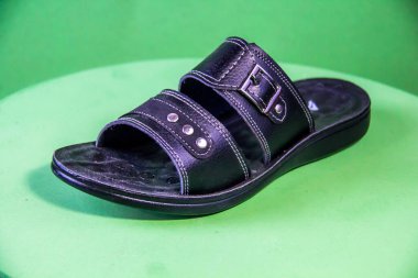 Illustrative Editorial branded photography, Slipper shouted on green Background, shot is selective focus with shallow depth of field. Photos taken at Cairo Egypt on 28 March 2019