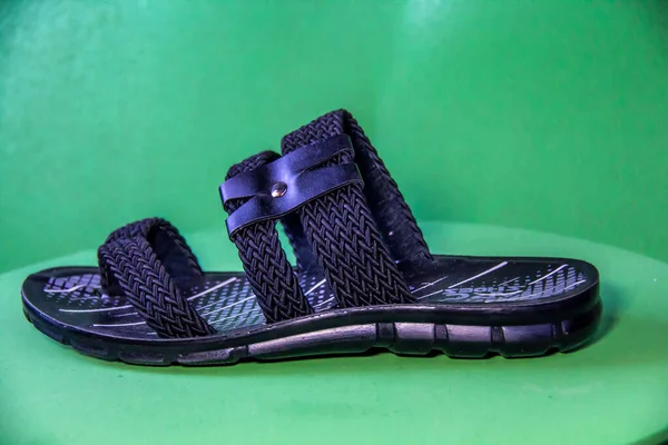 Illustrative Editorial branded photography, Slipper shouted on green Background, shot is selective focus with shallow depth of field. Photos taken at Cairo Egypt on 28 March 2019