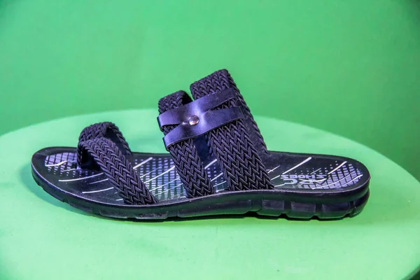 Illustrative Editorial branded photography, Slipper shouted on green Background, shot is selective focus with shallow depth of field. Photos taken at Cairo Egypt on 28 March 2019