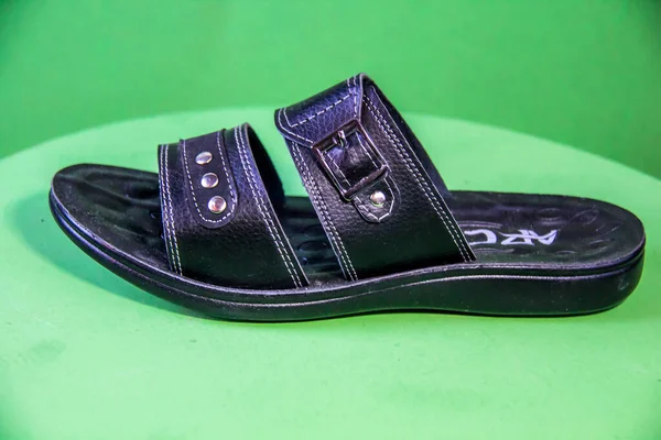 Illustrative Editorial branded photography, Slipper shouted on green Background, shot is selective focus with shallow depth of field. Photos taken at Cairo Egypt on 28 March 2019