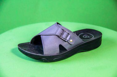 Illustrative Editorial branded photography, Slipper shouted on green Background, shot is selective focus with shallow depth of field. Photos taken at Cairo Egypt on 28 March 2019